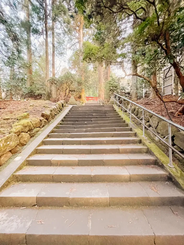 A stone staircase leading up to a red torii gate.