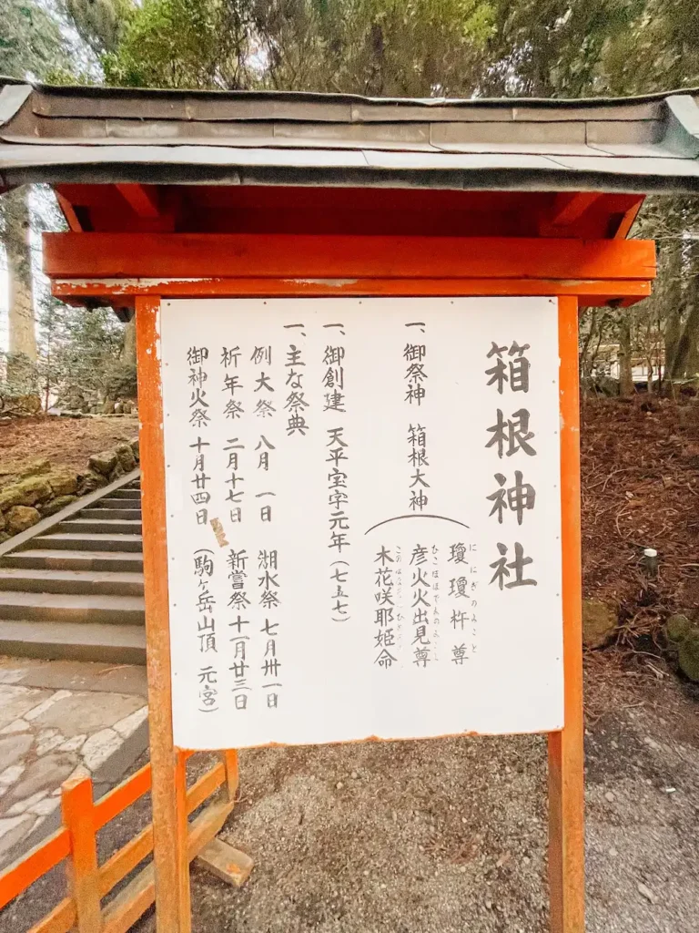 A red and white sign with information about the Hakone Shrine.